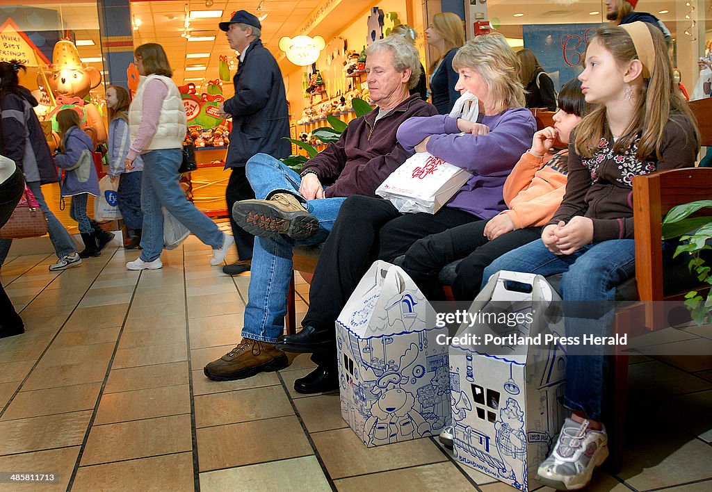 Gerard and Cathy Wescott, seated from left, of Bangor rest on a bench around 11 a.m. Friday with th