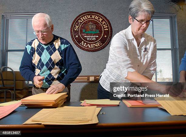 Photos by Doug Jones/Staff Photographer -- Ralph Masciovecchio and Town Clerk Tody Justice sort ballots before passing them to election workers for a...