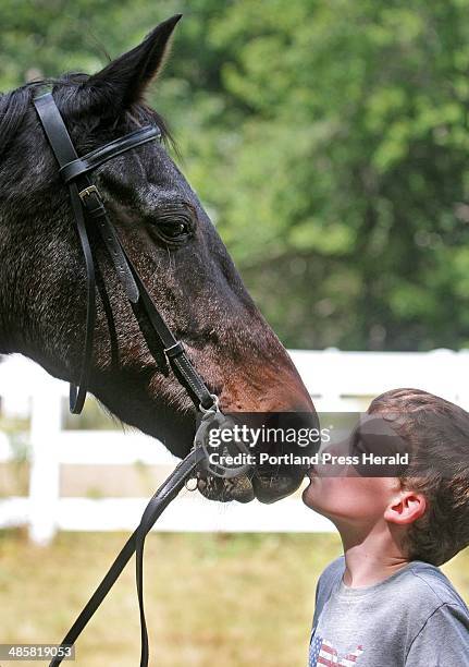 Jill Brady/Staff Photographer: -- Zach Ward of Pownal kisses Santana, a 23-year-old retired Standardbred owned by Cassidy Anderson also of Pownal,...