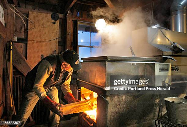 Gregory Rec/Staff Photographer -- Clark Cole puts wood in the firebox of his evaporator while boiling in his Dayton sugar house on Friday, March 7,...