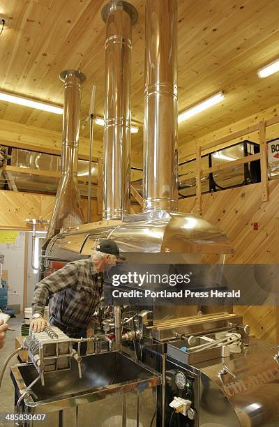 Gregory Rec/Staff Photographer: -- Bob Michaud checks on sap boilinging in an evaporator at the Thurston and Peters Sugar House in Newfield on...