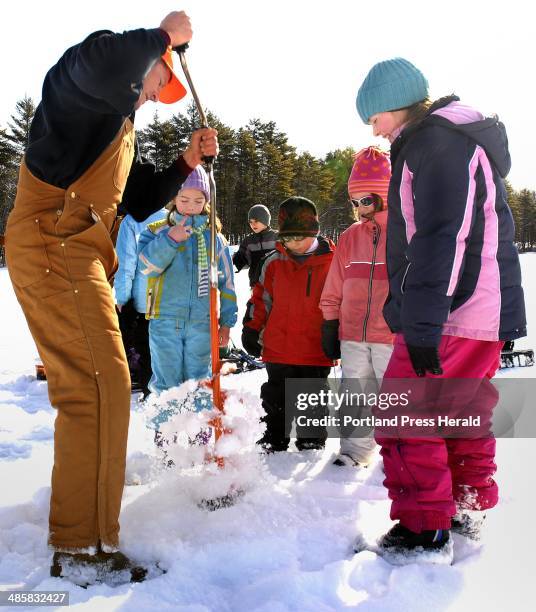 Doug Jones/staff photographer: -- Tuesday, January 2008: Bob Burns of Gorham drills through 15 inches of ice with a hand auger as his fisher folk...