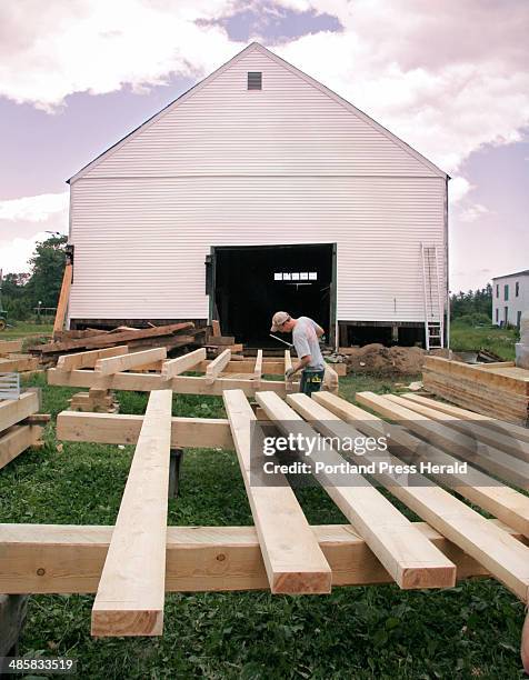Jill Brady/Staff Photographer: -- Jon Courtney works with hemlock timbers outside the dairy barn at Broadturn Farm in Scarborough on Wednesday, June...