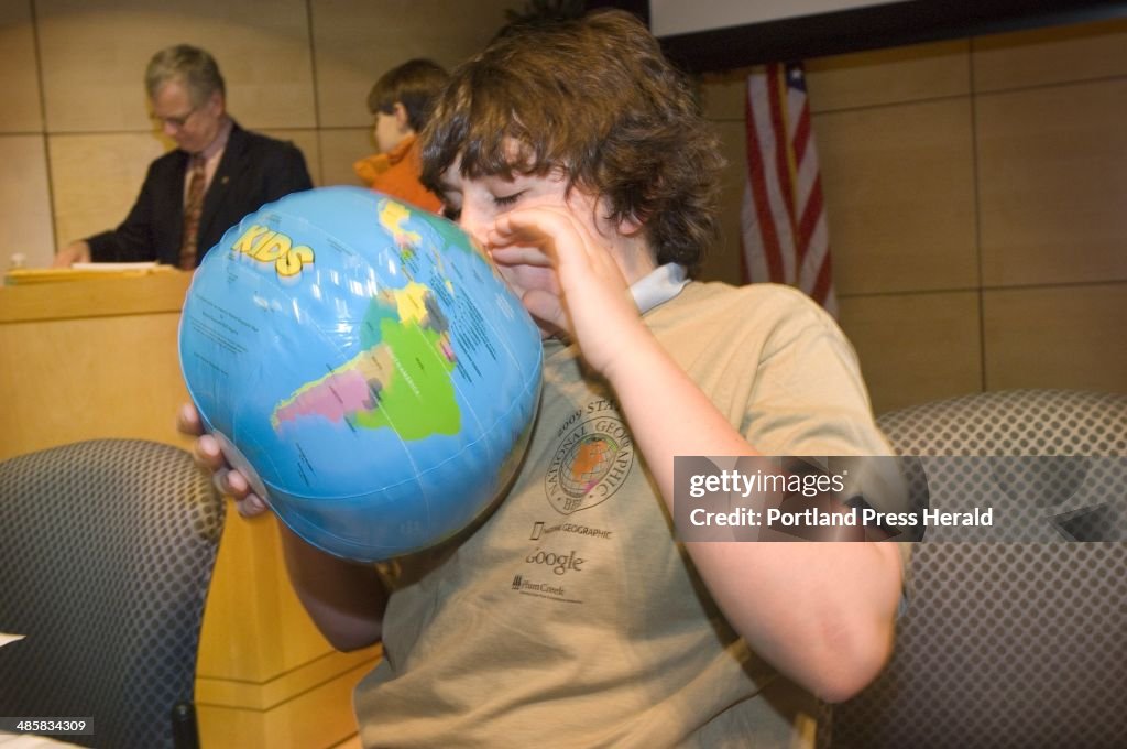 David Cavagnaro, of Kennebunk, blows up an inflatable globe, one of his prizes for second place in...