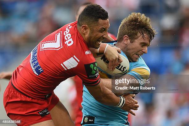 Kane Elgey of the Titans is tackled by Benji Marshall of the Dragons the round 25 NRL match between the Gold Coast Titans and the St George Illawarra...