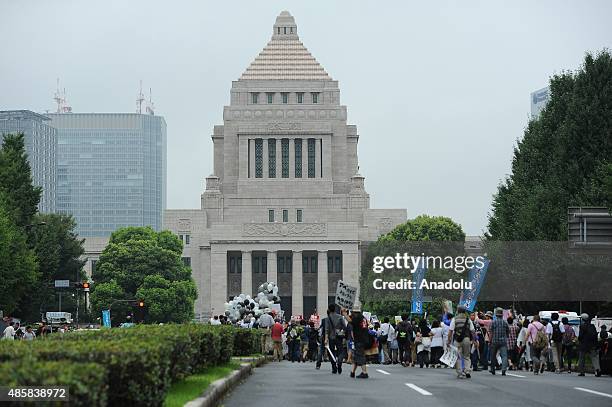 People take part a major protest labeled as a nationwide movement for 1 million people organized near the National Diet Building on August 30 in...