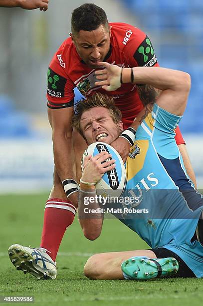 Kane Elgey of the Titans is tackled by Benji Marshall of the Dragons during the round 25 NRL match between the Gold Coast Titans and the St George...