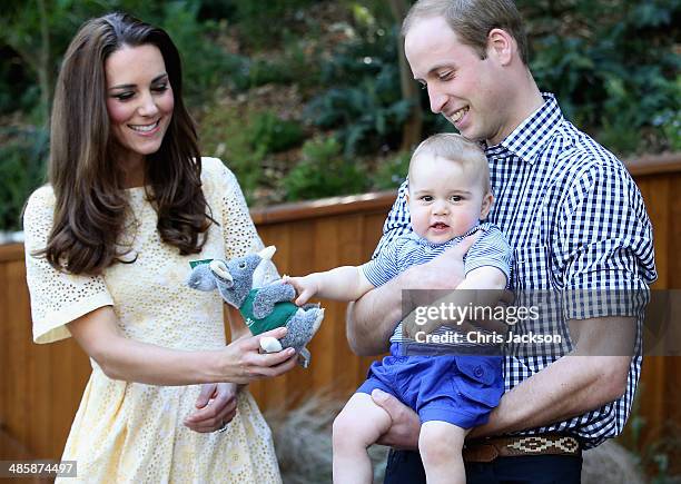 Prince William, Duke of Cambridge holds Prince George of Cambridge as Catherine, Duchess of Cambridge gives him a toy bilby during a visit to the...
