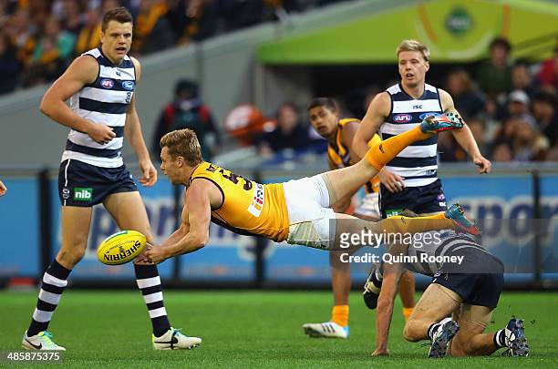 Sam Mitchell of the Hawks handballs during the round five AFL match between the Geelong Cats and the Hawthorn Hawks at Melbourne Cricket Ground on...