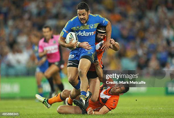 Jarryd Hayne of the Eels is tackled by Braith Anasta and Aaron Woods of the Tigers during the round seven NRL match between the Parramatta Eels and...