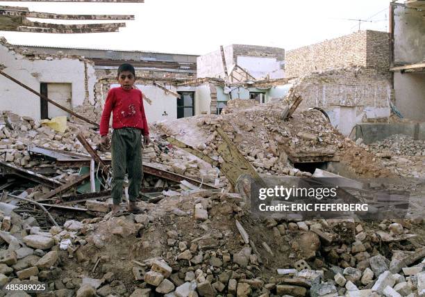 An Iranian boy stands 25 January 1987 on the ruins of his house in Ahvaz destroyed 23 January by an Iraqi air raid during the "war of the cities" as...