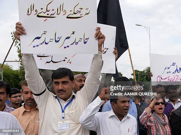 Pakistani journalists shout slogans during a protest against the attack on television journalist Hamid Mir by gunmen, in Islamabad on April 21, 2014....