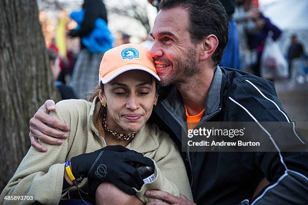 Couple huddles while waiting to load a bus to take them to the start of the Boston Marathon in the Boston Commons on April 21, 2014 in Boston,...