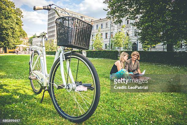 two young woman relaxing in the city park - lithuania woman stock pictures, royalty-free photos & images
