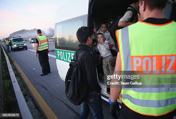 Police load a group of Afghan migrants into a van after the migrants crossed from Austria into Germany and were walking along the A3 highway in the...