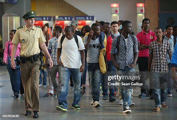 Police escort migrants who had arrived at Munich Hauptbahnhof main railway station on a train from Bologna, Italy, but who had no passports to a...