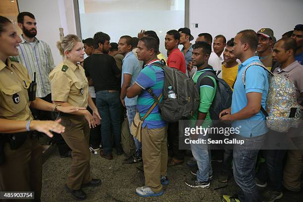 Migrants stand in a holding area after arriving at Munich Hauptbahnhof main railway station and being detained by police because the migrants had no...