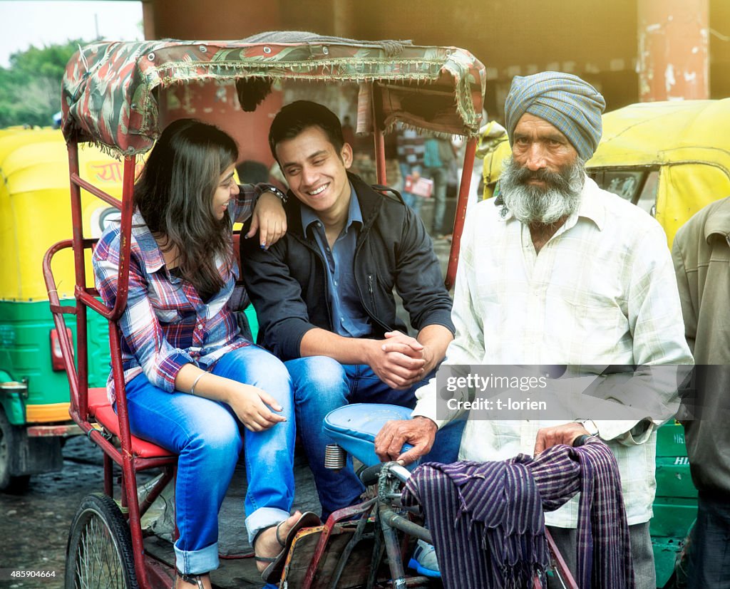 Young indian couple in rickshaw w their driver.