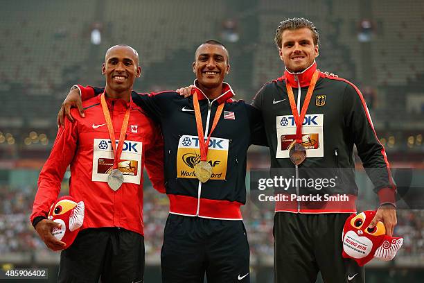 Silver medalist Damian Warner of Canada, gold medalist Ashton Eaton of the United States and bronze medalist Rico Freimuth of Germany pose on the...