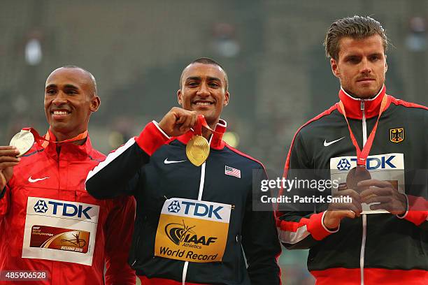 Silver medalist Damian Warner of Canada, gold medalist Ashton Eaton of the United States and bronze medalist Rico Freimuth of Germany pose on the...