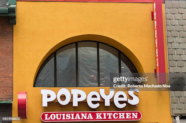 Signage of Popeyes Louisiana Kitchen on a yellow background. Popeyes Louisiana Kitchen is an American chain of fried chicken fast food restaurants...