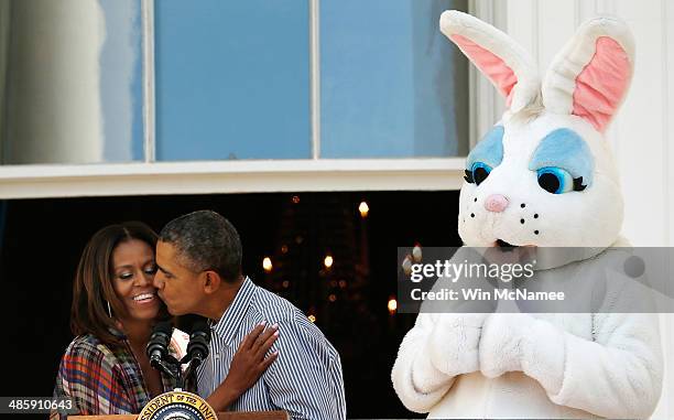 President Barack Obama kisses first lady Michelle Obama at the annual White House Easter Egg Roll on the South Lawn April 21, 2014 in Washington, DC....