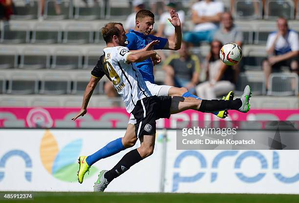 Maik Lukowicz of Rostock is challenged by Sebastian Neumann of Aalen during the third league match between VfR Aalen and Hansa Rostock at...
