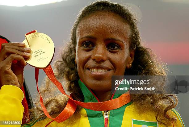 Gold medalist Mare Dibaba of Ethiopia poses on the podium during the medal ceremony for the Women's Marathon final during day nine of the 15th IAAF...