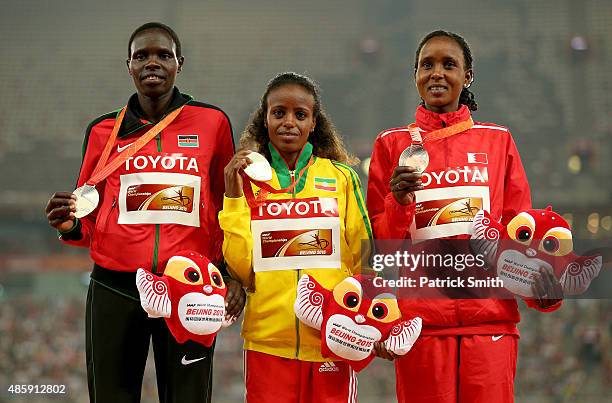 Silver medalist Helah Kiprop of Kenya, gold medalist Mare Dibaba of Ethiopia and bronze medalist Eunice Jepkirui Kirwa of Bahrain pose on the podium...