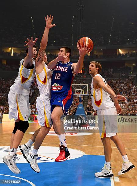 Nando de Colo of France is challenged by Tibor Pleiss, Anton Gavel and Dirk Nowitzki of Germany during the Men's Basketball friendly match between...