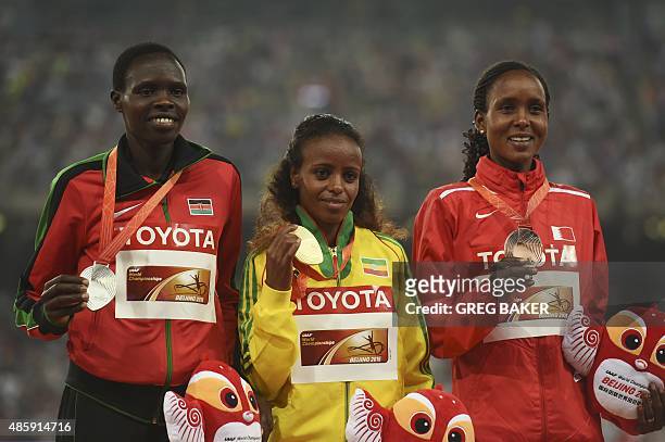 Silver medallist Kenya's Helah Kiprop, gold medallist Ethiopia's Mare Dibaba and bronze medallist Bahrain's Eunice Jepkirui Kirwa celebrate on the...