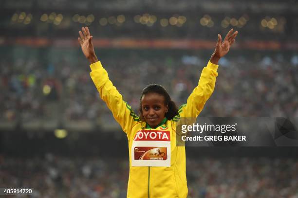 Gold medallist Ethiopia's Mare Dibaba celebrates on the podium during the victory ceremony for the women's marathon athletics event at the 2015 IAAF...