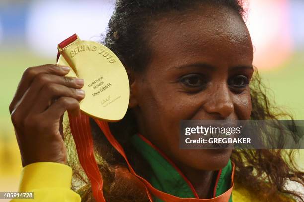 Gold medallist Ethiopia's Mare Dibaba shows off her medal on the podium during the victory ceremony for the women's marathon athletics event at the...