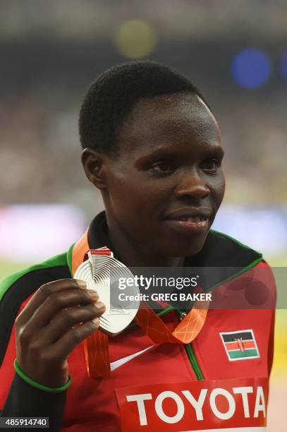 Silver medallist Kenya's Helah Kiprop shows off her medal on the podium during the victory ceremony for the women's marathon athletics event at the...