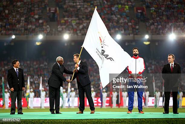 President Lamine Diack hands over the IAAF flag to President of UK athletics Lynn Davies during the closing ceremony during day nine of the 15th IAAF...