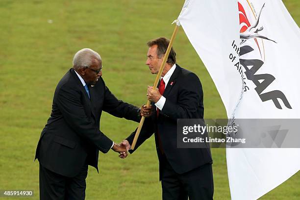 President Lamine Diack hands over the IAAF flag to President of UK athletics Lynn Davies during the closing ceremony during day nine of the 15th IAAF...
