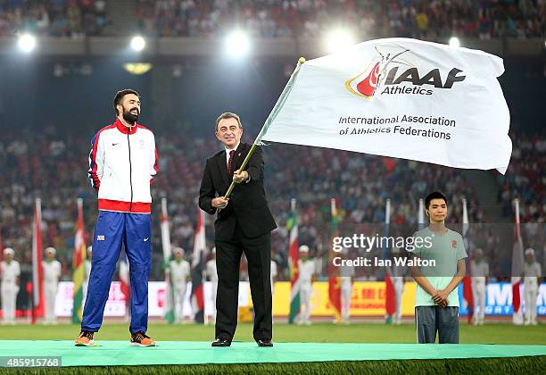 Martyn Rooney Captain of Great Britain watches as Simon Cooper, Head of Sport, Mayor's Office at Greater London Authority waives the IAAF flag during...