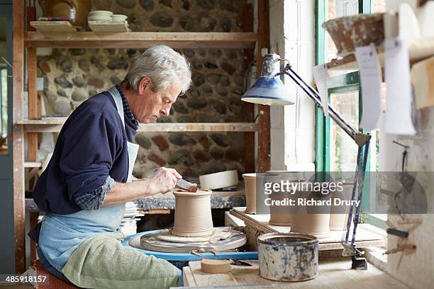 potter turning the footring of a cutlery drainer - potter's wheel stock pictures, royalty-free photos & images