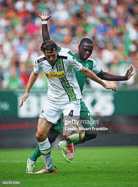 Anthony Ujah of Bremen is challenged by Roel Brouwers of Gladbach during the Bundesliga match between Werder Bremen and Borussia Moenchengladbach at...