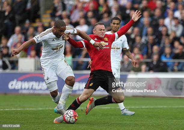Wayne Rooney of Manchester United is tackled by Ashley Williams of Swansea City but no penalty is given during the Barclays Premier League match...