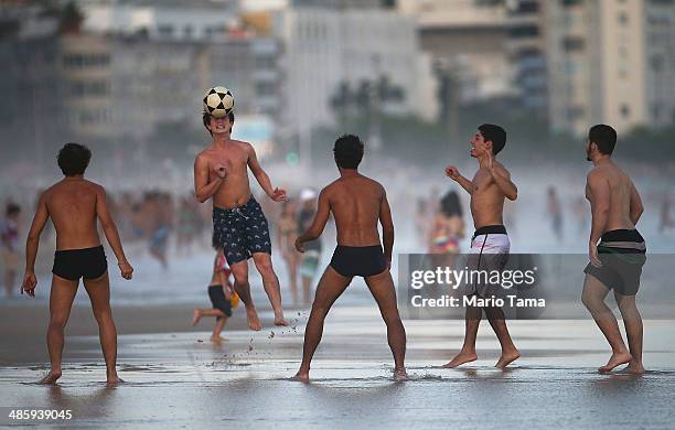 Brazilians play altinha, a spin-off of soccer played on the beach, as others gather on Ipanema Beach on April 21, 2014 in Rio de Janeiro, Brazil....