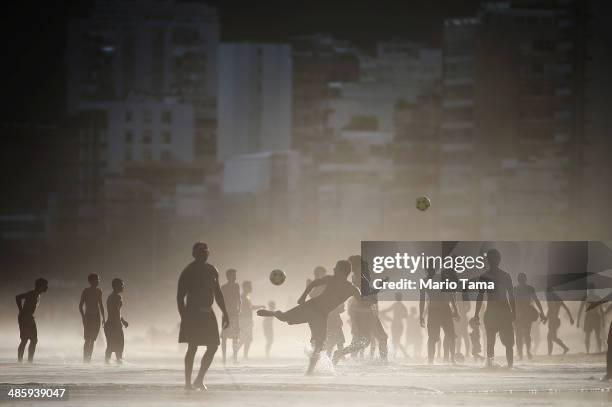 Brazilians play altinha, a spin-off of soccer played on the beach, as others gather on Ipanema Beach on April 21, 2014 in Rio de Janeiro, Brazil....