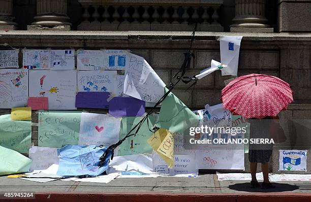 Woman stares at signs against President Otto Perez Molina, stuck on the eve by demonstrators at the Congress building in Guatemala City on August 30...