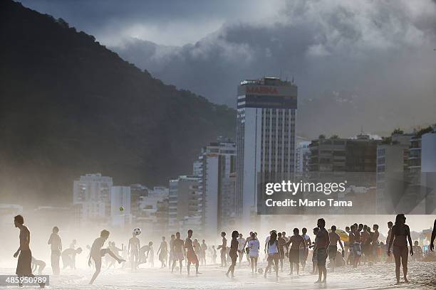 Brazilians play altinha, a spin-off of soccer played on the beach, as others gather on Ipanema Beach in a low-lying mist on April 21, 2014 in Rio de...