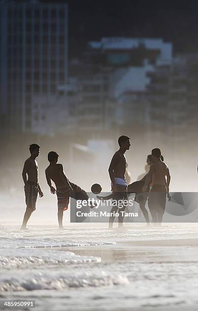 Brazilians play altinha, a spin-off of soccer played on the beach, as others gather on Ipanema Beach on April 21, 2014 in Rio de Janeiro, Brazil....