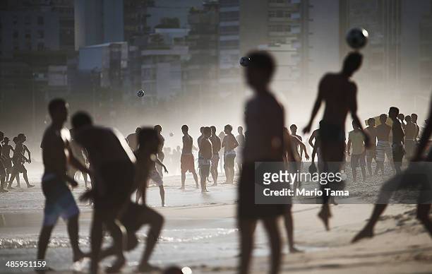 Brazilians play altinha, a spin-off of soccer played on the beach, as others gather on Ipanema Beach in a low-lying mist on April 21, 2014 in Rio de...