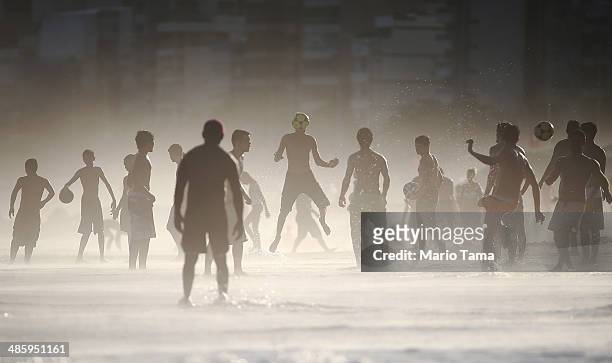 Brazilians play altinha, a spin-off of soccer played on the beach, as others gather on Ipanema Beach in a low-lying mist on April 21, 2014 in Rio de...