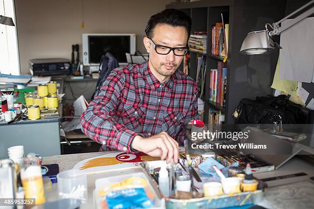 an artist working on a piece using paint - plaid shirt 個照片及圖片檔