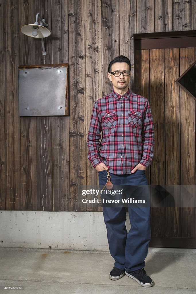 A man standing in front of a wooden building