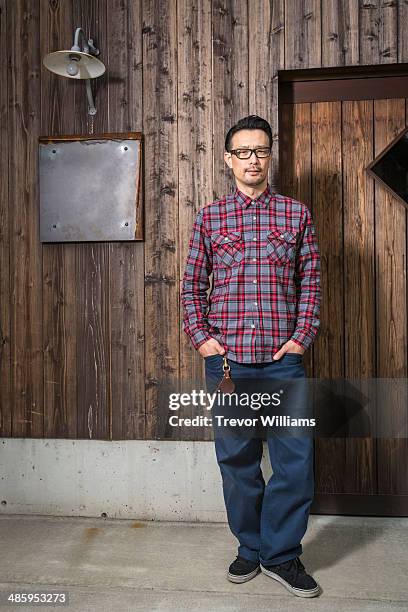 a man standing in front of a wooden building - chemise à carreaux photos et images de collection